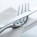 set of silverware on white napkin